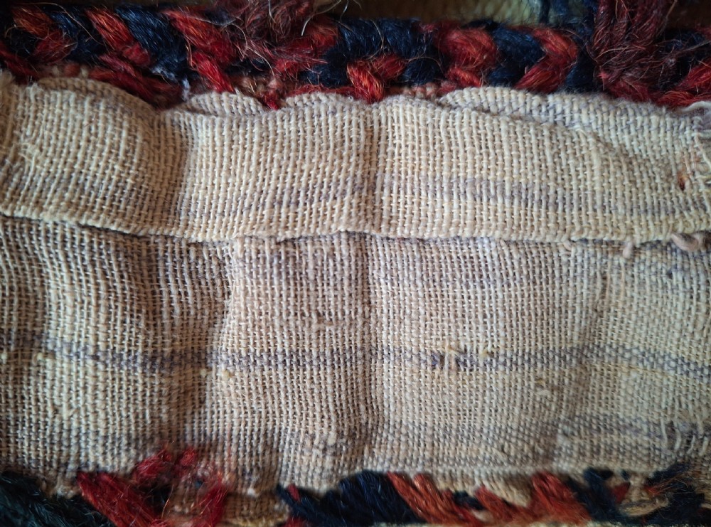 A pair of handwoven wool Turkoman camel neck trappings featuring geometric red and cream bands trimmed with dense multicoloured tassels. View VIII
