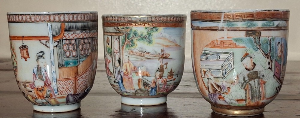 A set of three 18th-century Chinese export porcelain handleless cups decorated with hand-painted polychrome figures and landscape scenes.