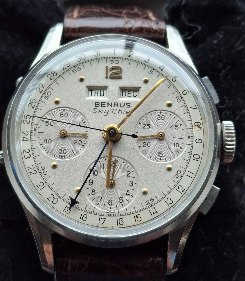 A 1940s Benrus Sky Chief stainless steel wristwatch with a cream triple date chronograph dial and brown leather strap.