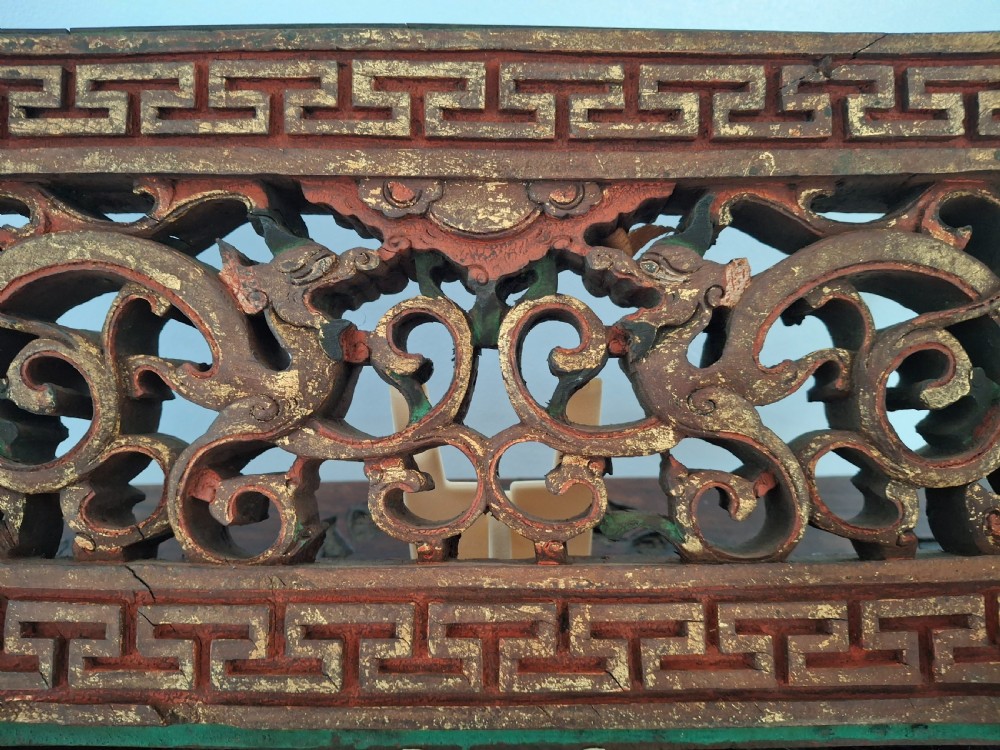 Set of twelve rectangular Chinese carved wooden panels featuring openwork scroll design, key fret borders, and worn red, green, and gold painted finishes. View II