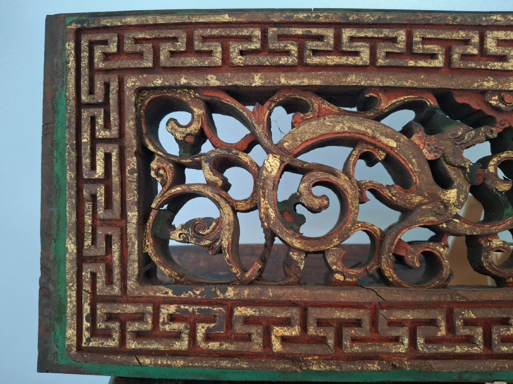 Set of twelve rectangular Chinese carved wooden panels featuring openwork scroll design, key fret borders, and worn red, green, and gold painted finishes. View III