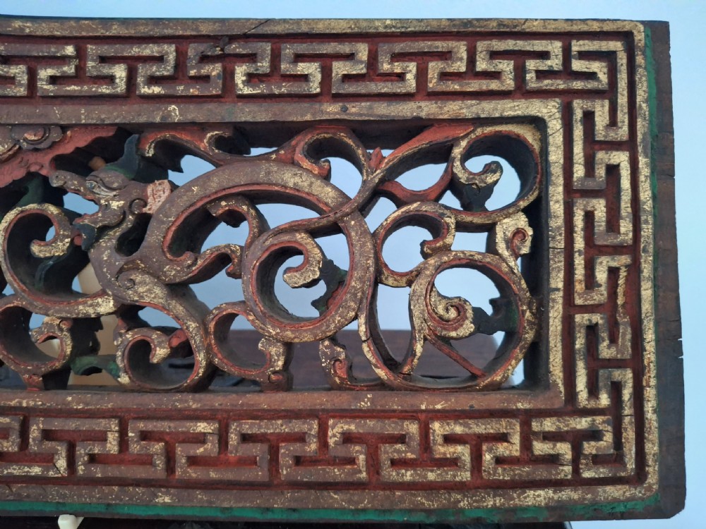 Set of twelve rectangular Chinese carved wooden panels featuring openwork scroll design, key fret borders, and worn red, green, and gold painted finishes. View IV