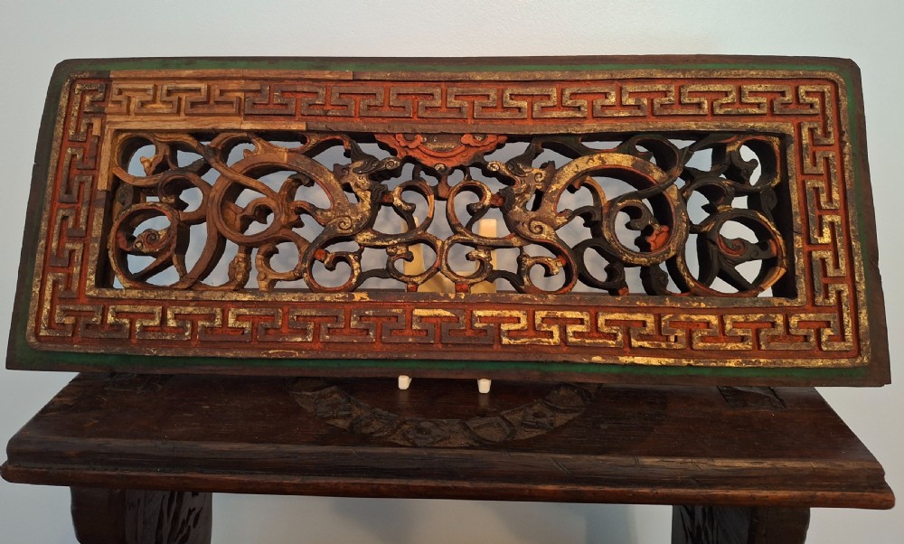 Set of twelve rectangular Chinese carved wooden panels featuring openwork scroll design, key fret borders, and worn red, green, and gold painted finishes. View V