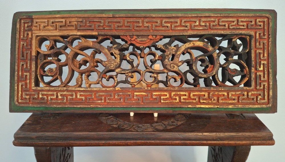 Set of twelve rectangular Chinese carved wooden panels featuring openwork scroll design, key fret borders, and worn red, green, and gold painted finishes. View VI