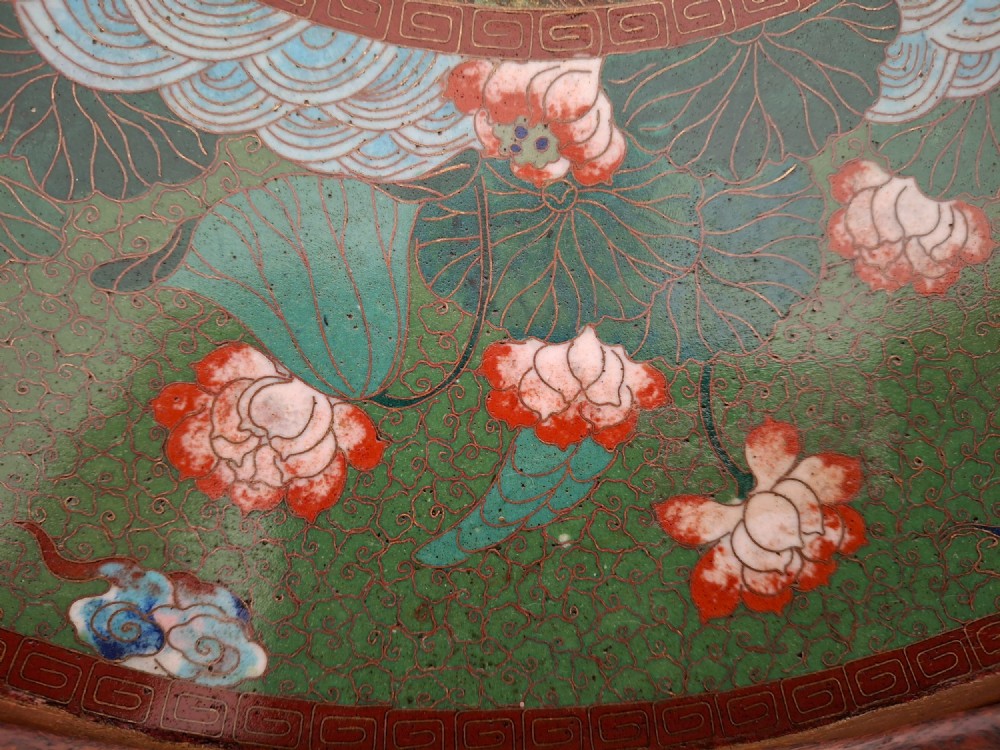 A circular Meiji period Japanese cloisonne enamel charger featuring central haloed figures surrounded by a lotus pattern on a green background. View VI