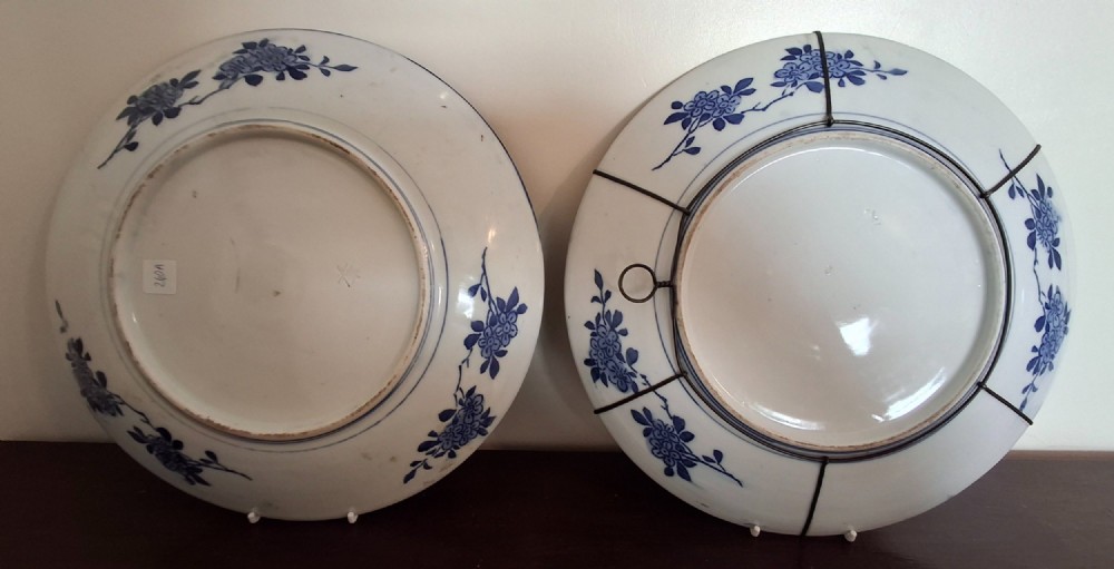 A pair of circular Japanese Totai Shippo porcelain plates depicting birds, lotus flowers, and peonies in polychrome enamel against a textured brown tree bark effect ground. View X