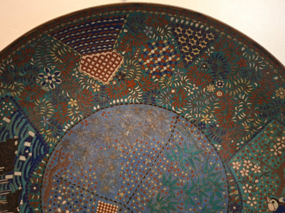A circular Japanese cloisonne enamel charger decorated with geometric reserves, floral patterns, foliage, and bird motifs in blue, green, and terracotta tones. View VII