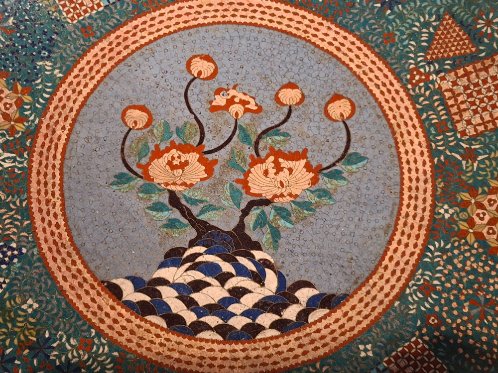 Large circular antique Japanese cloisonne enamel charger featuring a central peony motif surrounded by intricate geometric and floral diaper patterns in teal, blue, and coral hues. View II