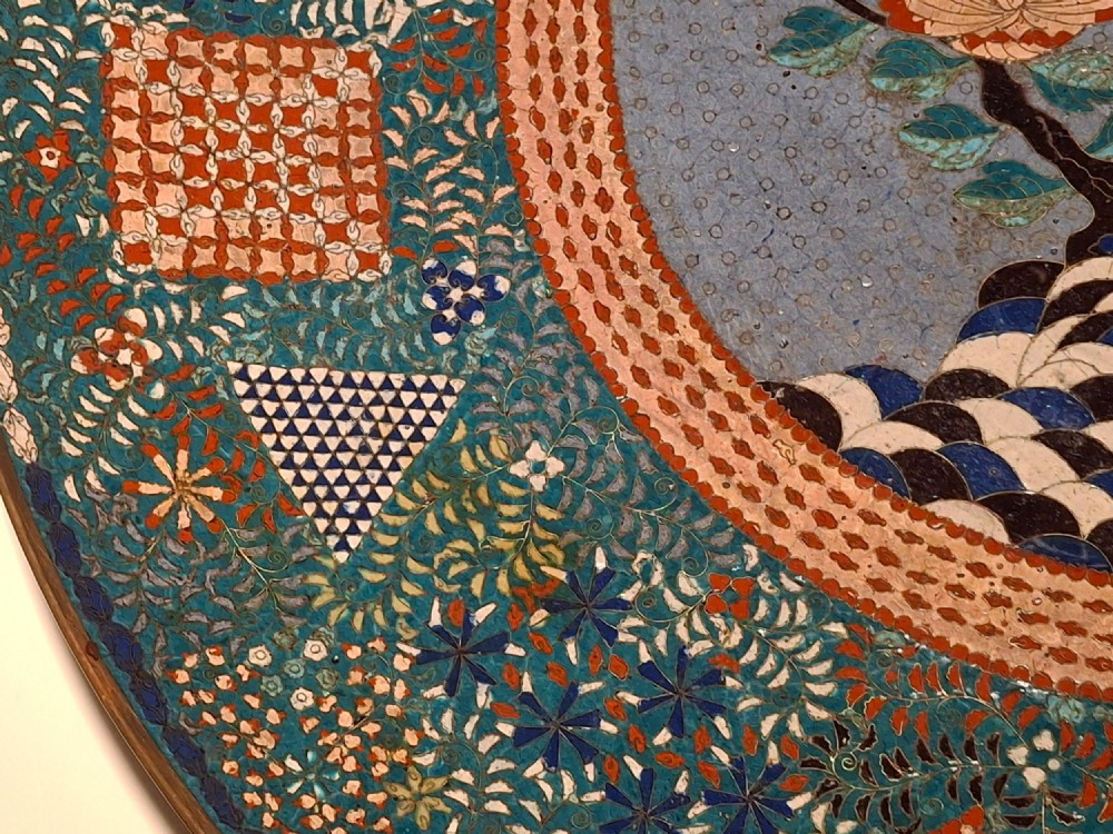Large circular antique Japanese cloisonne enamel charger featuring a central peony motif surrounded by intricate geometric and floral diaper patterns in teal, blue, and coral hues. View IX