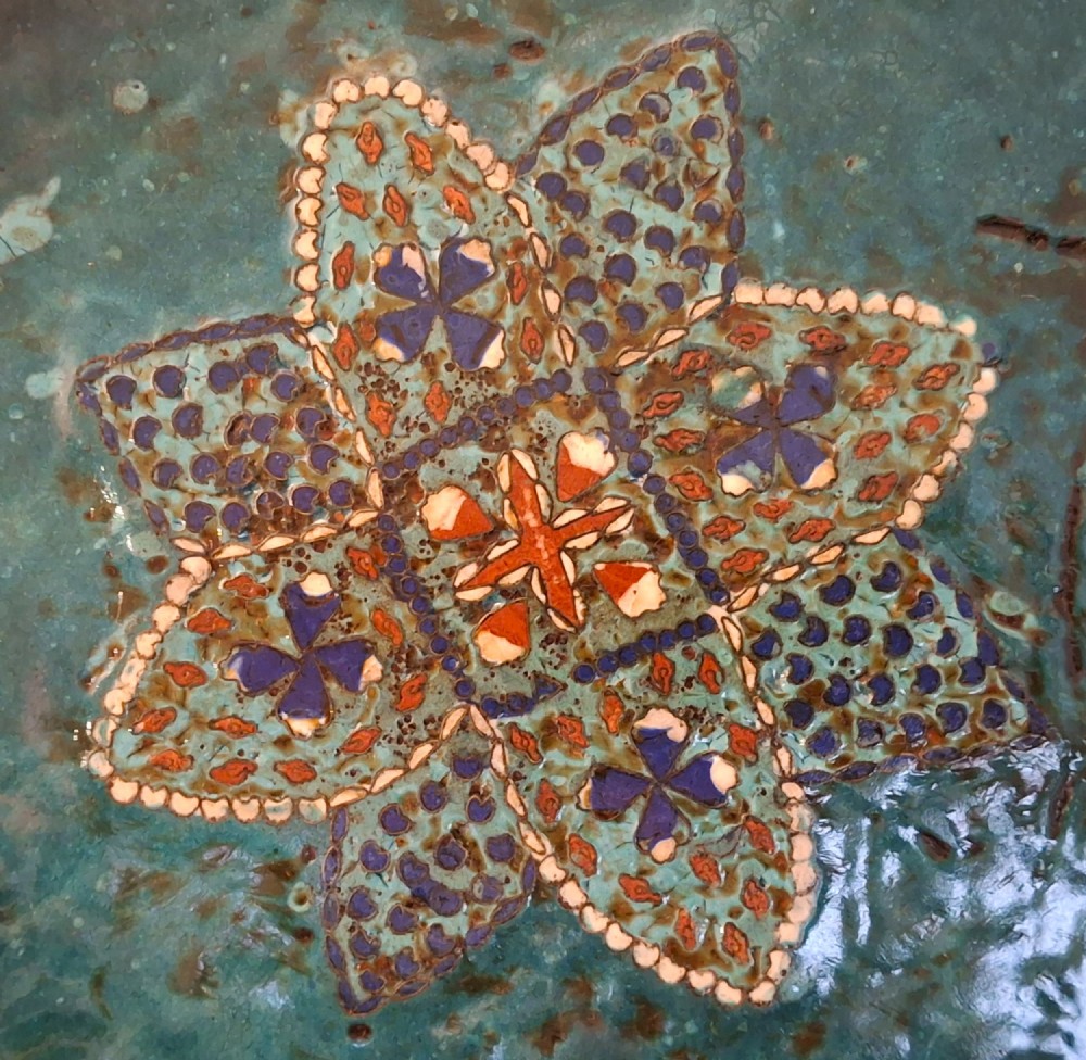 Large circular antique Japanese cloisonne enamel charger featuring a central peony motif surrounded by intricate geometric and floral diaper patterns in teal, blue, and coral hues. View XII