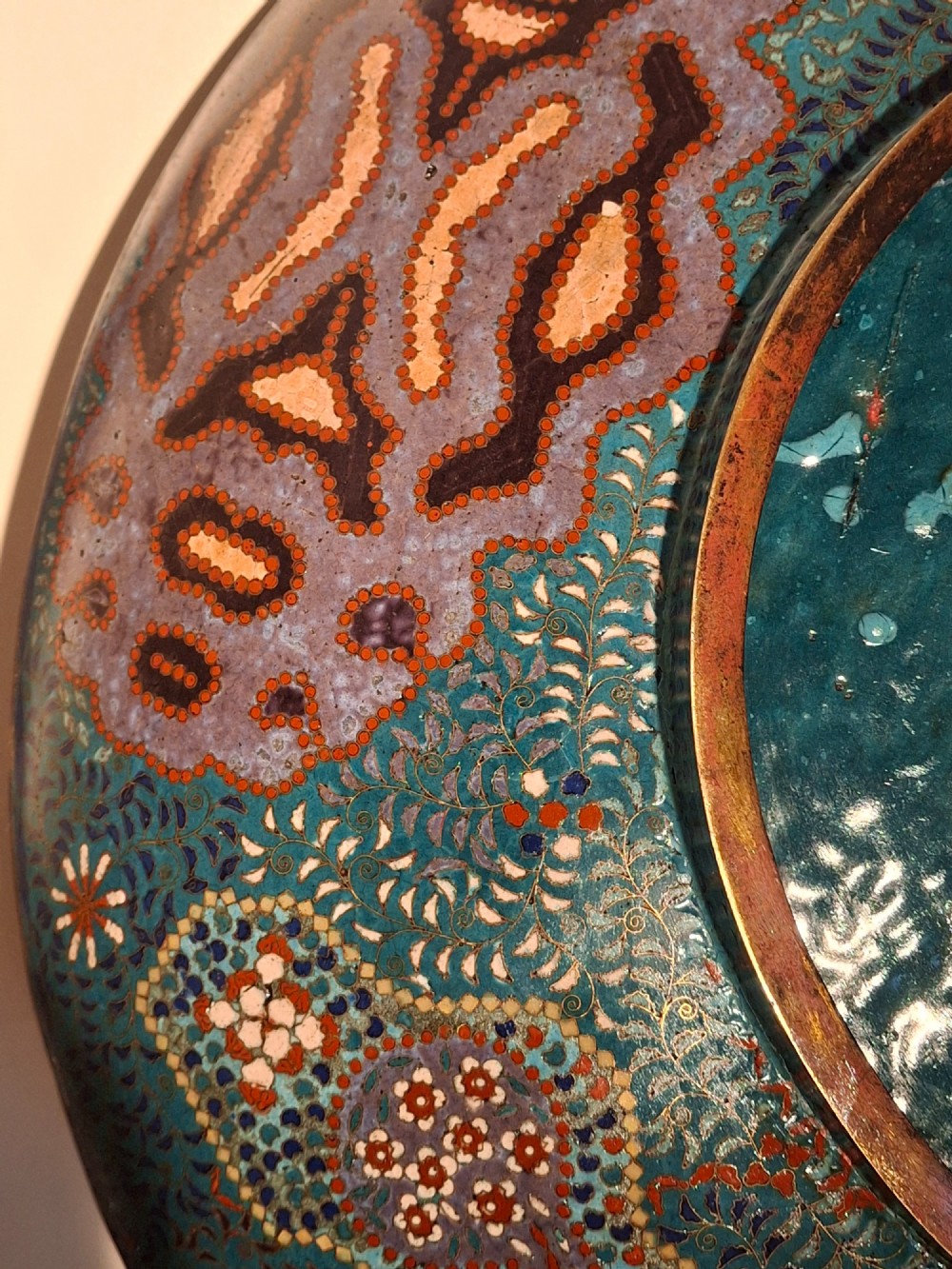 Large circular antique Japanese cloisonne enamel charger featuring a central peony motif surrounded by intricate geometric and floral diaper patterns in teal, blue, and coral hues. View XV