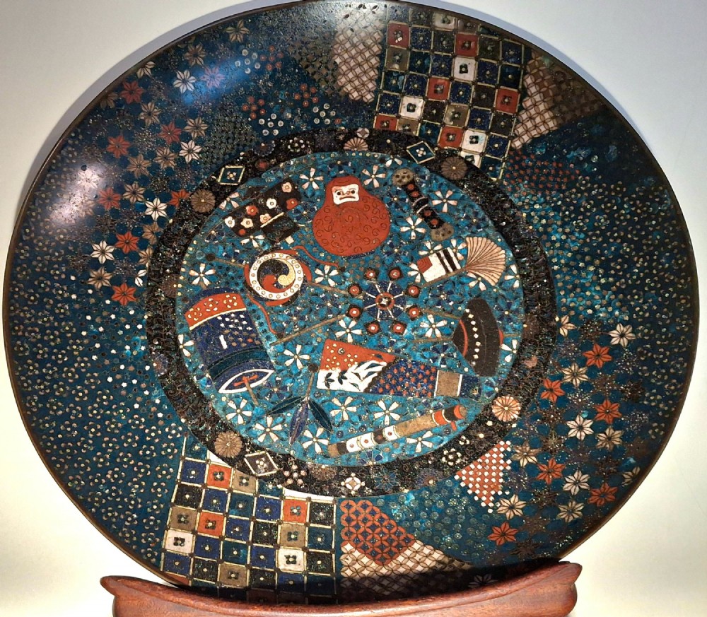 A circular Japanese cloisonne charger featuring a central blue medallion with a red Daruma figure surrounded by detailed geometric and floral patterned borders. View III