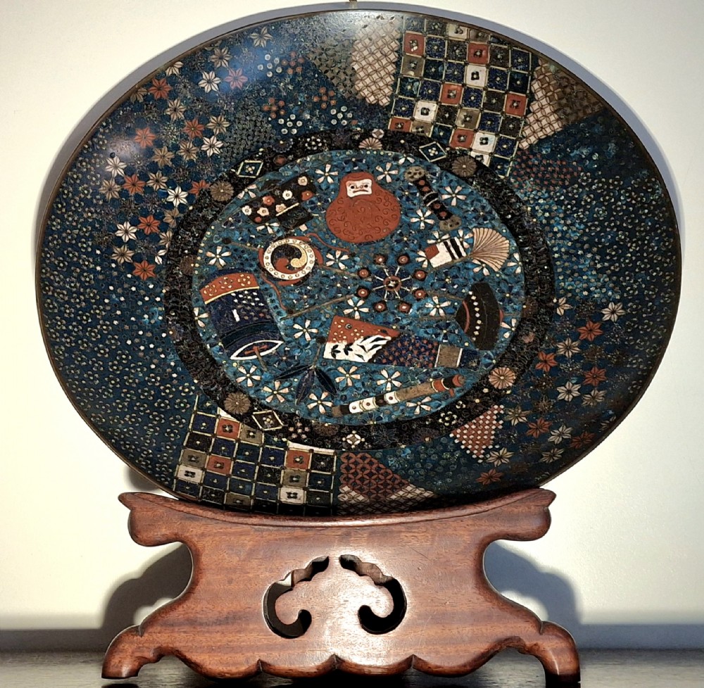 A circular Japanese cloisonne charger featuring a central blue medallion with a red Daruma figure surrounded by detailed geometric and floral patterned borders. View II
