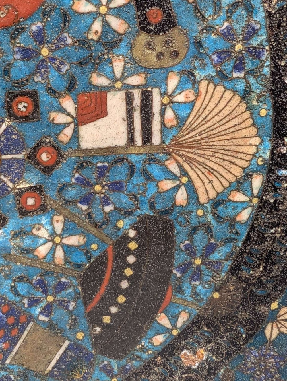 A circular Japanese cloisonne charger featuring a central blue medallion with a red Daruma figure surrounded by detailed geometric and floral patterned borders. View IX