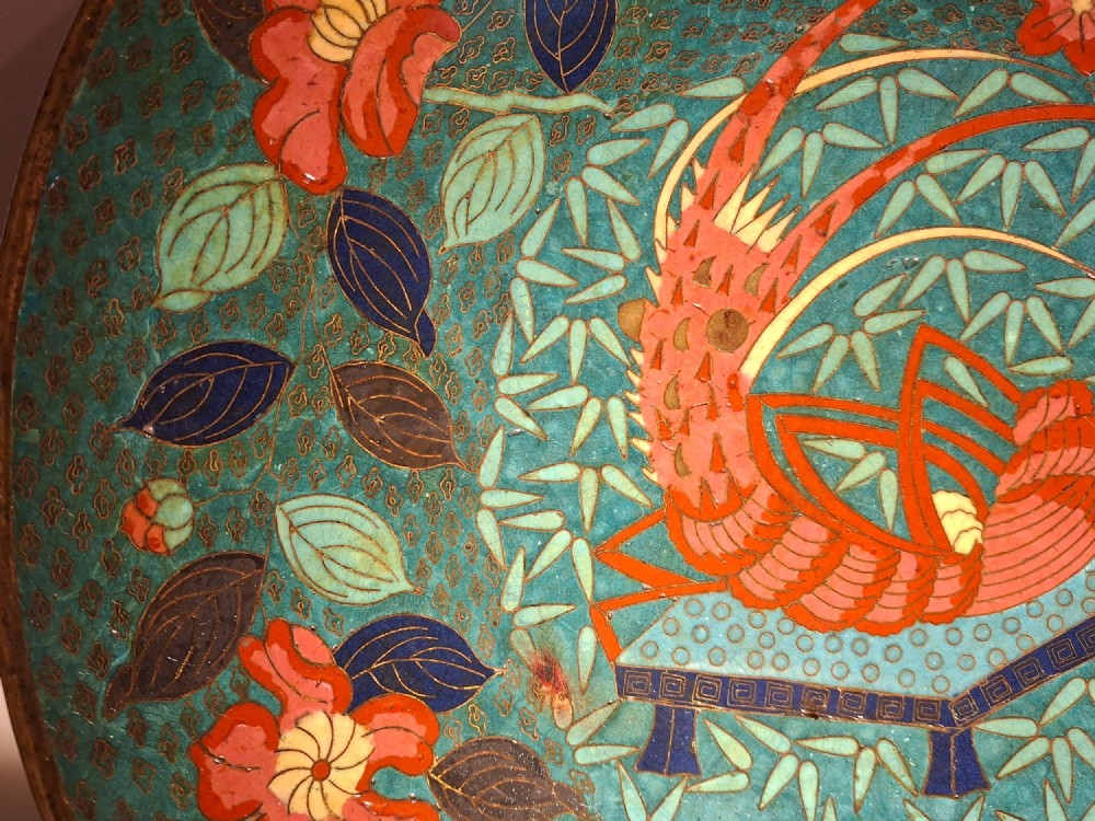 A circular Japanese cloisonne enamel charger displaying an orange shrimp motif surrounded by red flowers on a teal green pattern background. View IV