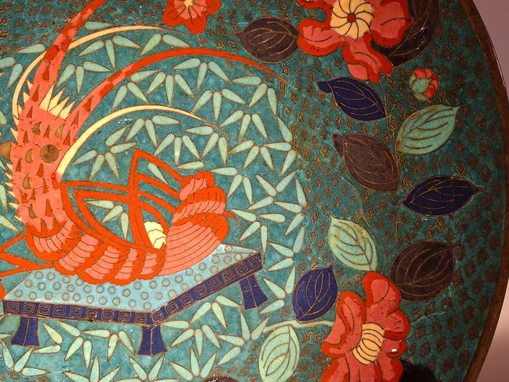 A circular Japanese cloisonne enamel charger displaying an orange shrimp motif surrounded by red flowers on a teal green pattern background. View V