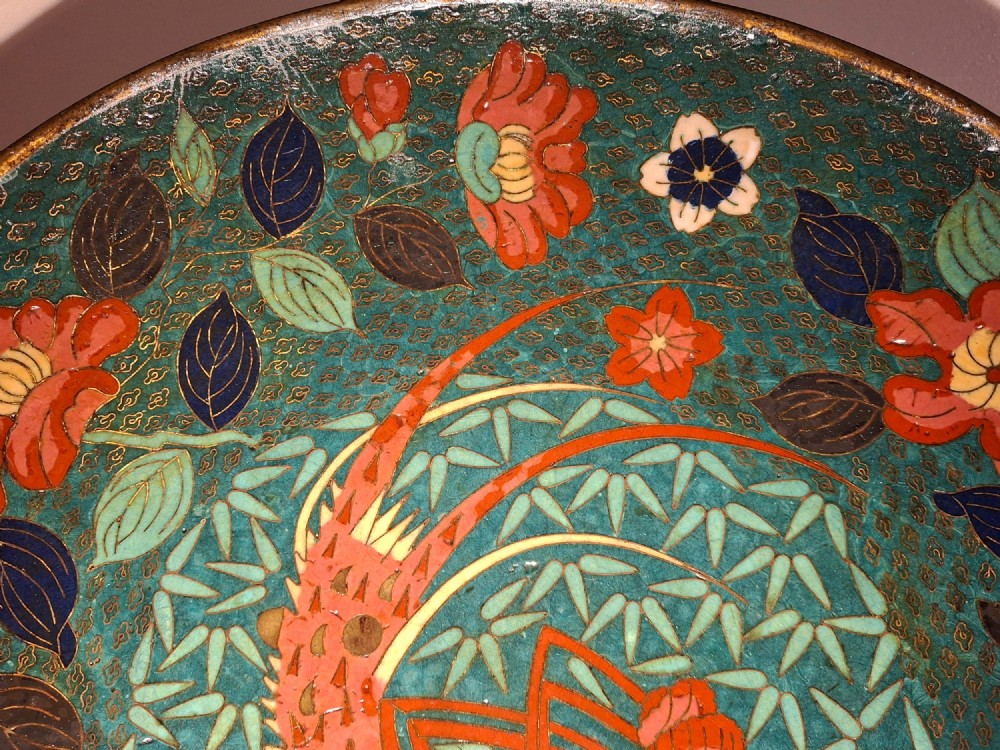 A circular Japanese cloisonne enamel charger displaying an orange shrimp motif surrounded by red flowers on a teal green pattern background. View VII