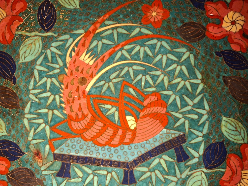 A circular Japanese cloisonne enamel charger displaying an orange shrimp motif surrounded by red flowers on a teal green pattern background. View VIII
