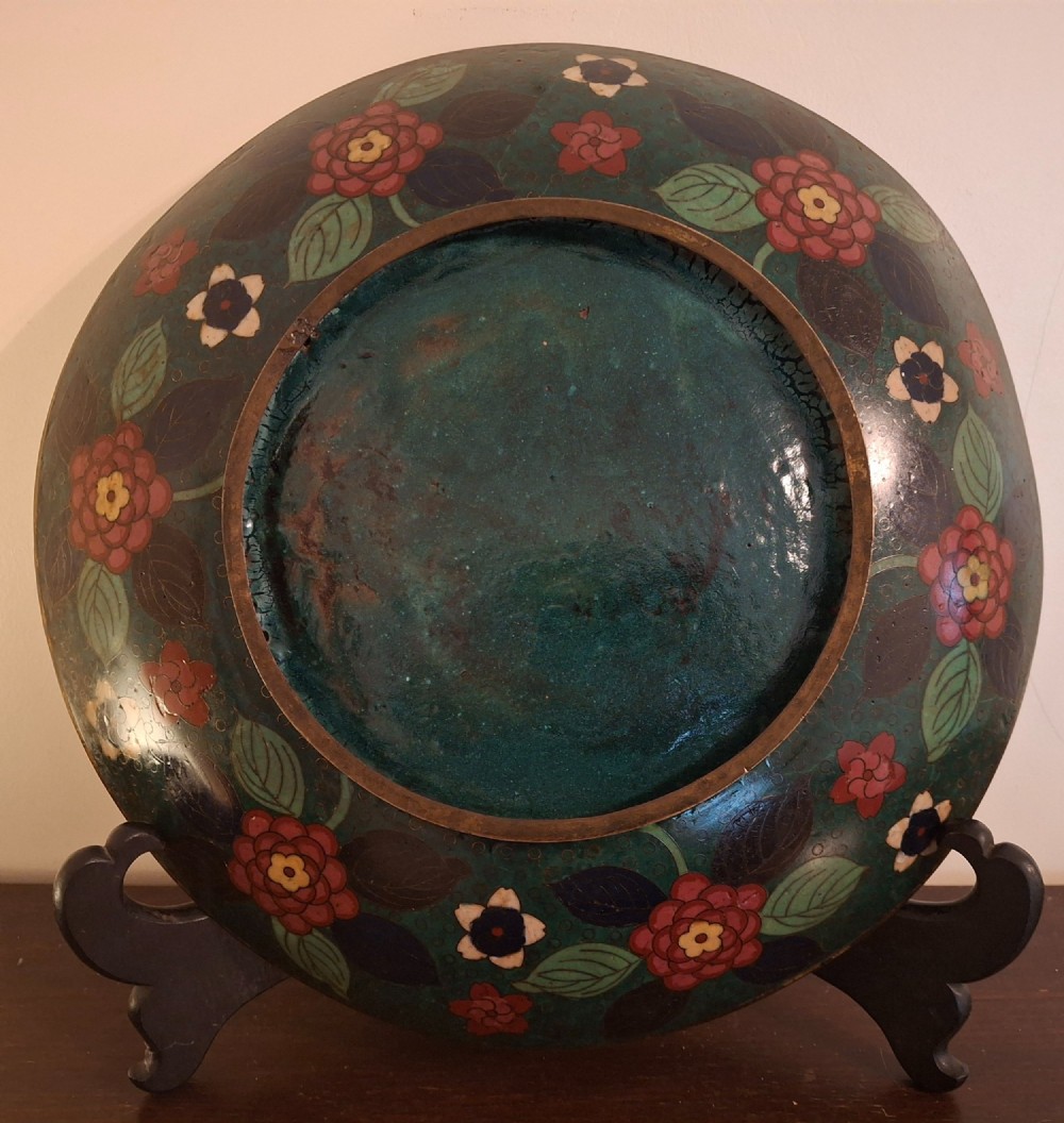 A circular Japanese cloisonne enamel charger displaying an orange shrimp motif surrounded by red flowers on a teal green pattern background. View IX