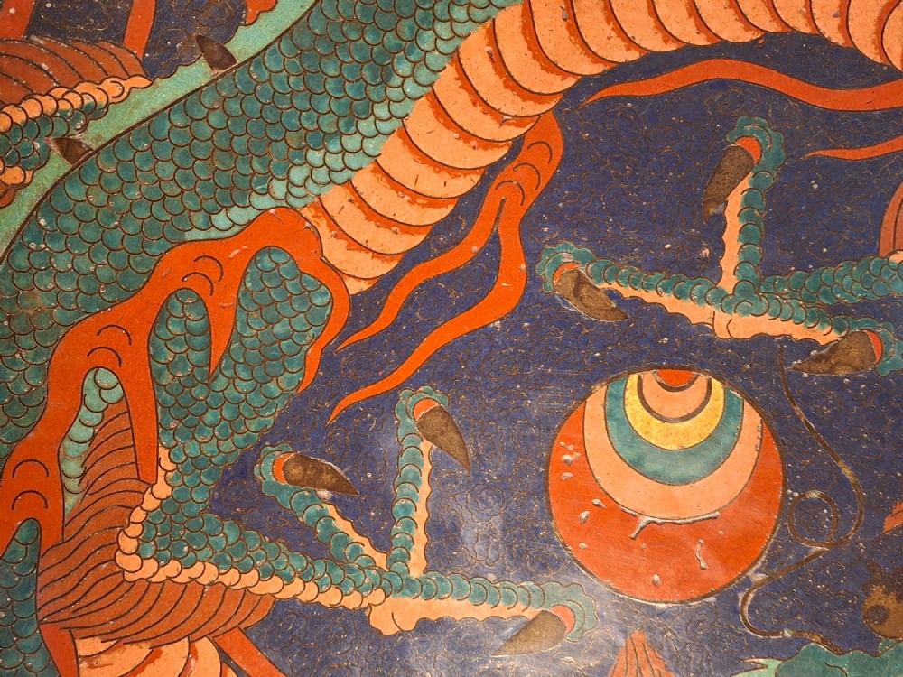 A circular Japanese Meiji period cloisonne enamel charger featuring a green and terracotta coiling dragon surrounding a flaming pearl on a dark blue background. View IV