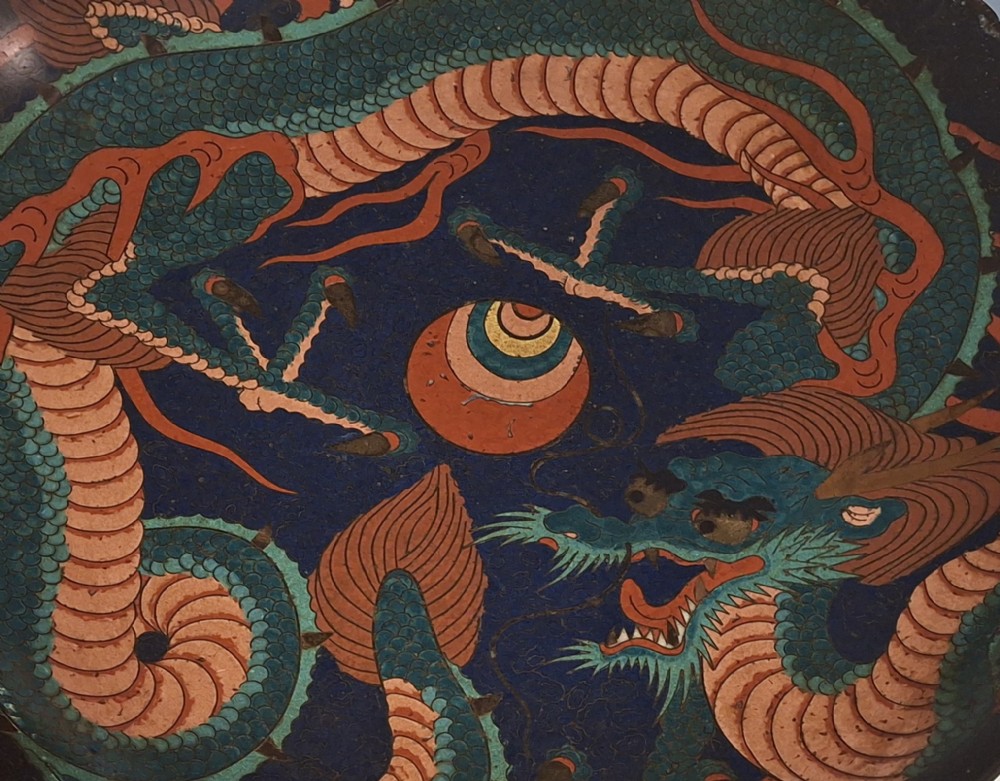 A circular Japanese Meiji period cloisonne enamel charger featuring a green and terracotta coiling dragon surrounding a flaming pearl on a dark blue background. View VII