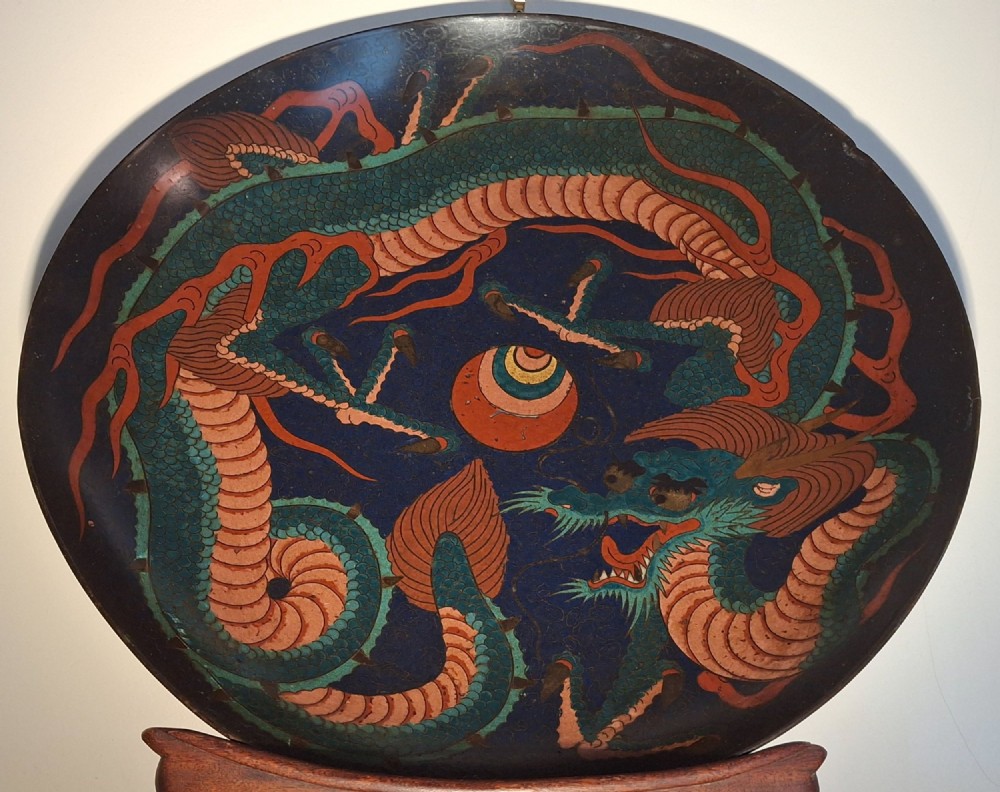 A circular Japanese Meiji period cloisonne enamel charger featuring a green and terracotta coiling dragon surrounding a flaming pearl on a dark blue background. View VIII