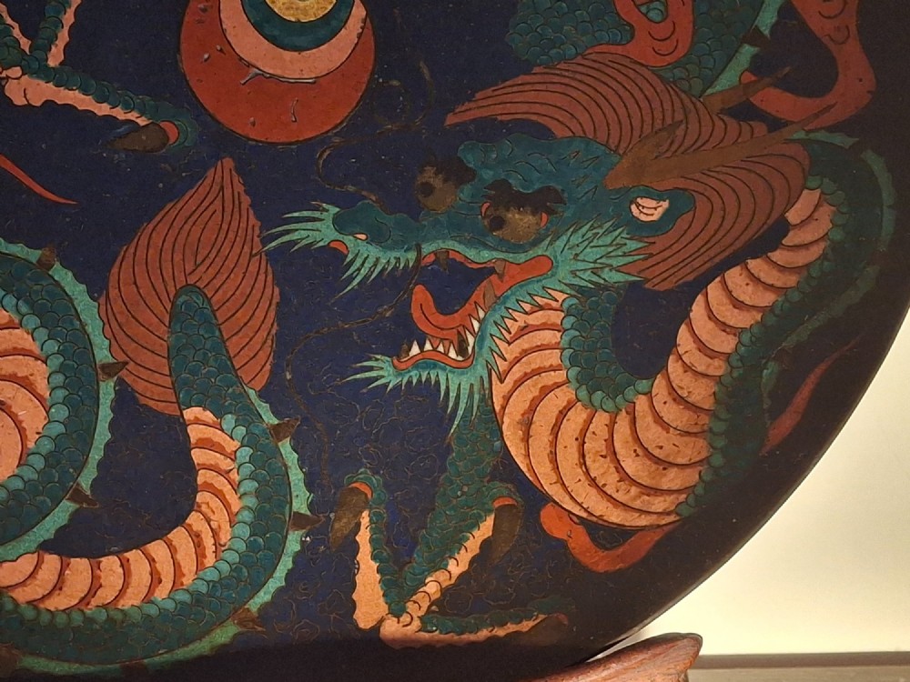 A circular Japanese Meiji period cloisonne enamel charger featuring a green and terracotta coiling dragon surrounding a flaming pearl on a dark blue background. View XI