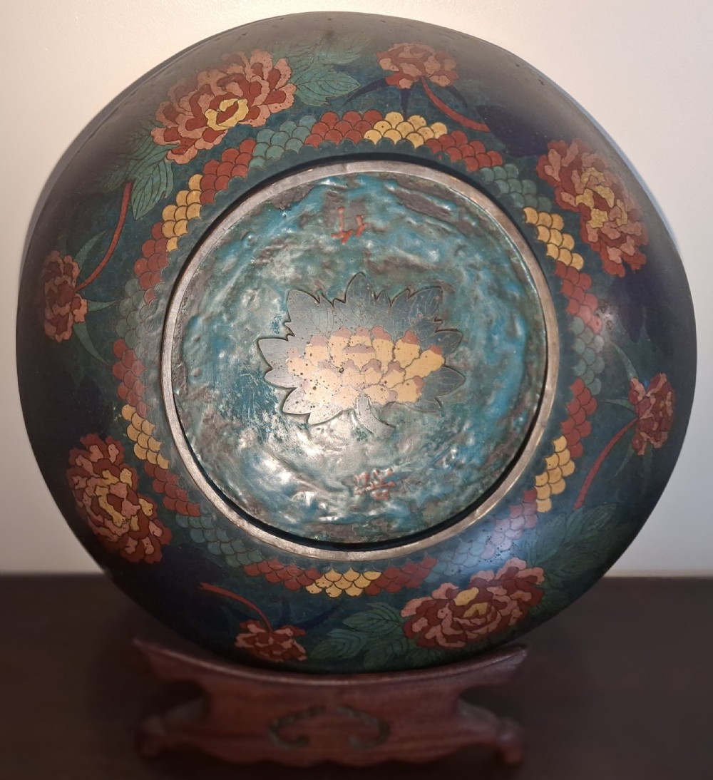 A circular Japanese Meiji period cloisonne enamel charger featuring a green and terracotta coiling dragon surrounding a flaming pearl on a dark blue background. View XII