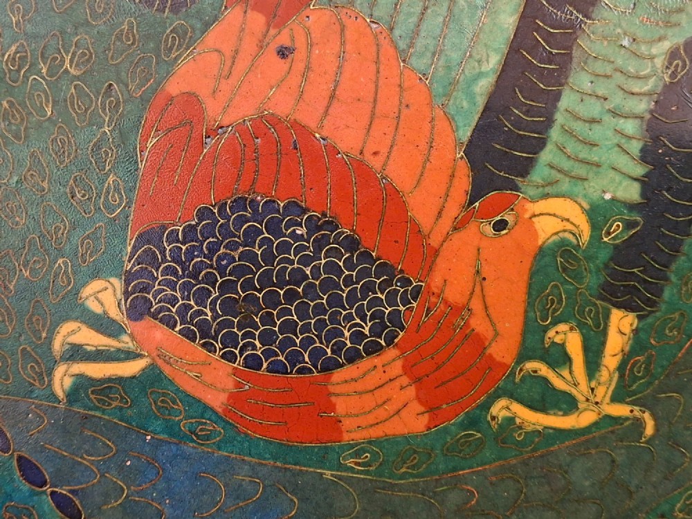 A circular antique Japanese cloisonne charger featuring a central bird motif surrounded by large orange peony blossoms on a green patterned enamel ground. View III
