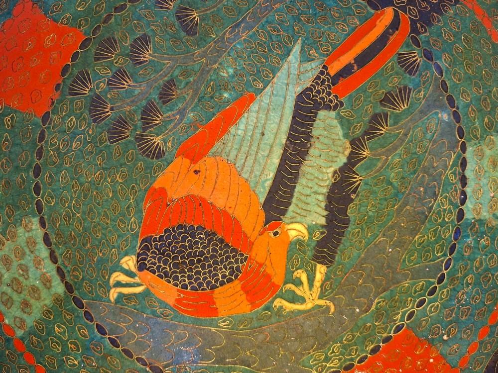 A circular antique Japanese cloisonne charger featuring a central bird motif surrounded by large orange peony blossoms on a green patterned enamel ground. View V