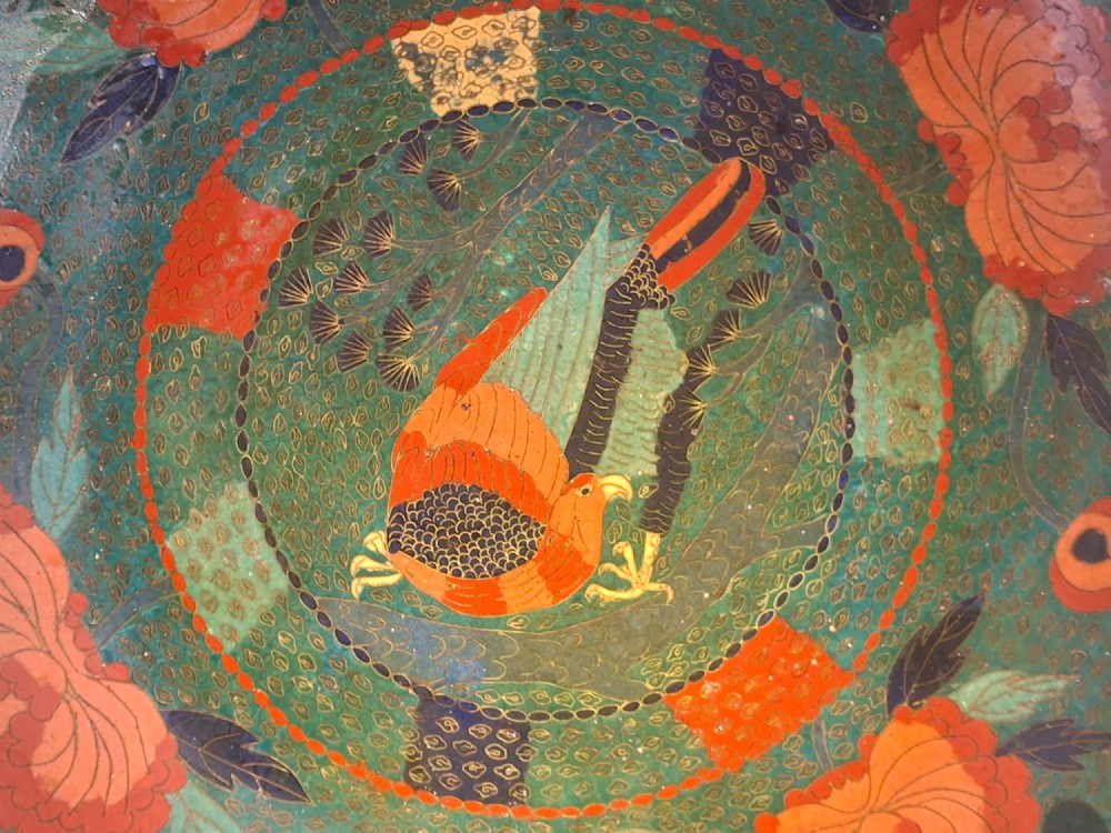 A circular antique Japanese cloisonne charger featuring a central bird motif surrounded by large orange peony blossoms on a green patterned enamel ground. View VI