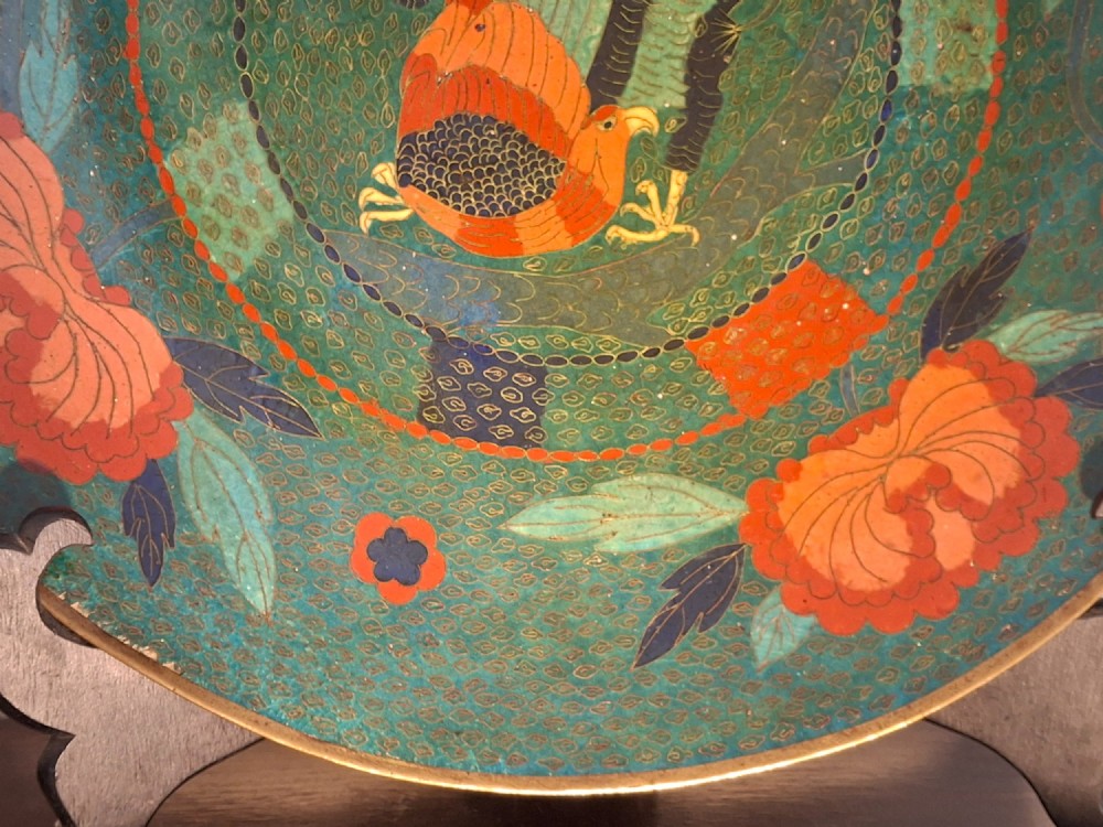 A circular antique Japanese cloisonne charger featuring a central bird motif surrounded by large orange peony blossoms on a green patterned enamel ground. View VII