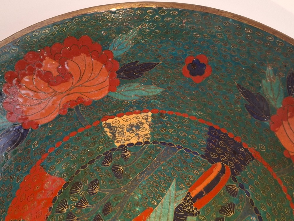 A circular antique Japanese cloisonne charger featuring a central bird motif surrounded by large orange peony blossoms on a green patterned enamel ground. View VIII