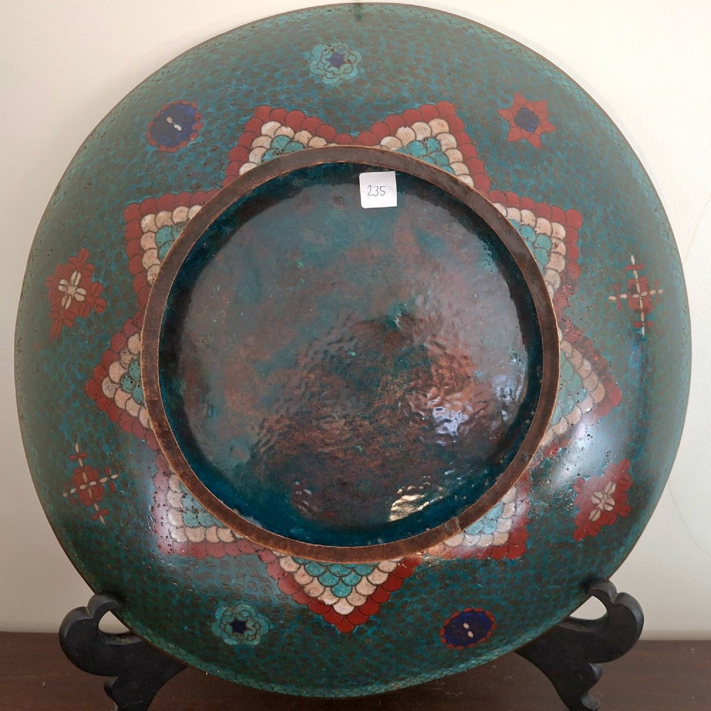 A circular antique Japanese cloisonne charger featuring a central bird motif surrounded by large orange peony blossoms on a green patterned enamel ground. View XI