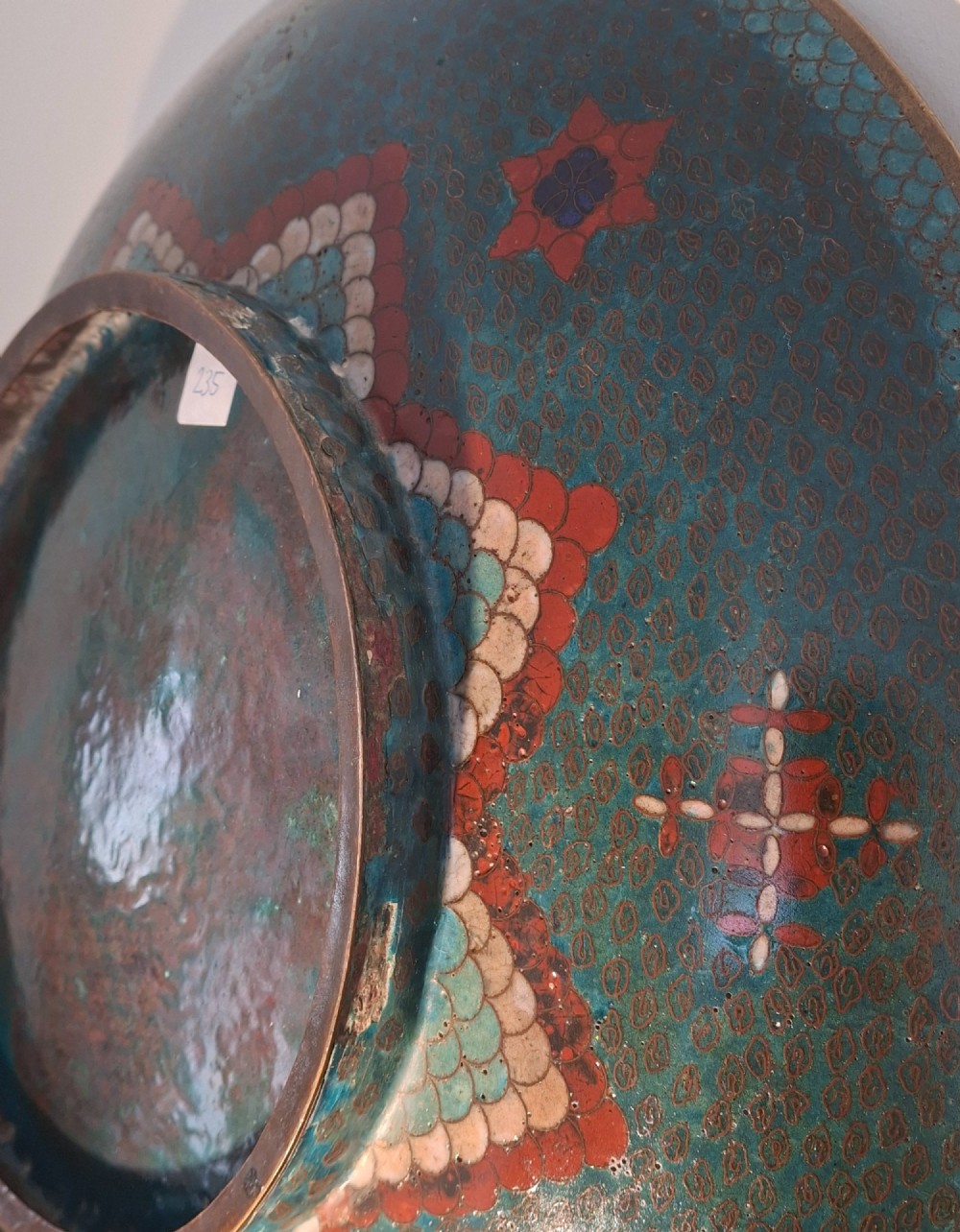 A circular antique Japanese cloisonne charger featuring a central bird motif surrounded by large orange peony blossoms on a green patterned enamel ground. View XII