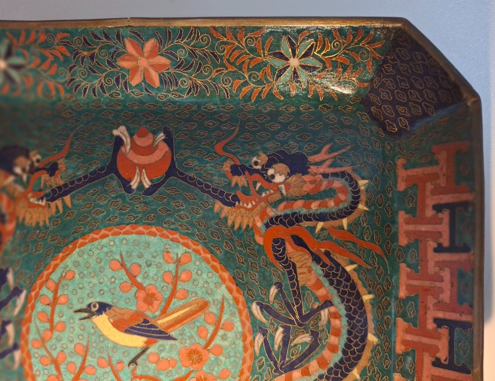 Square Japanese cloisonne enamel tray featuring a central bird motif surrounded by two coiled dragons on a teal patterned ground. View VI