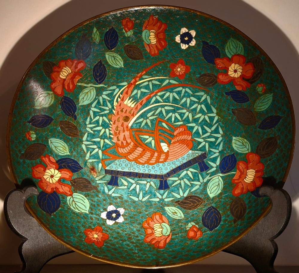 A circular Japanese cloisonne enamel charger displaying an orange shrimp motif surrounded by red flowers on a teal green pattern background. View II