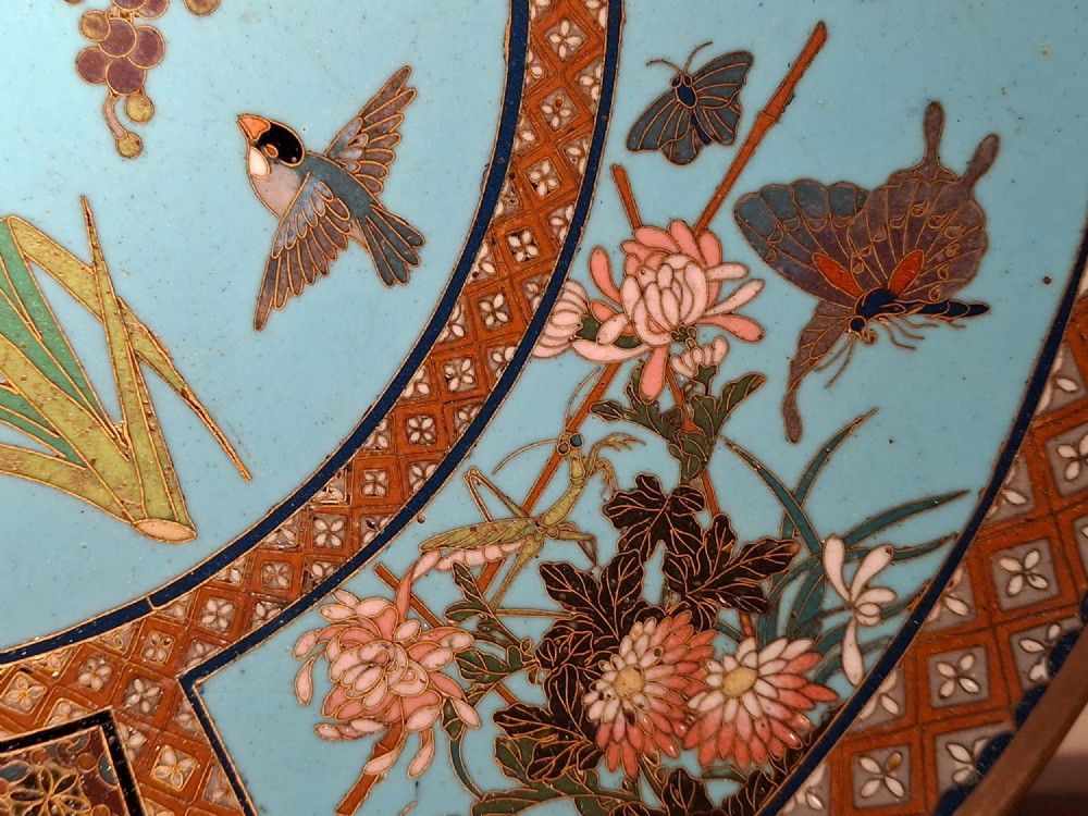 A circular Japanese cloisonne enamel charger featuring a central turquoise medallion with a floral vase and birds, enclosed by patterned borders and surrounding nature panels. View VI