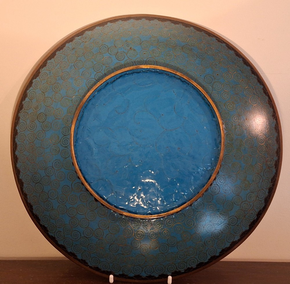 A circular Japanese cloisonne enamel charger featuring a central turquoise medallion with a floral vase and birds, enclosed by patterned borders and surrounding nature panels. View XIV