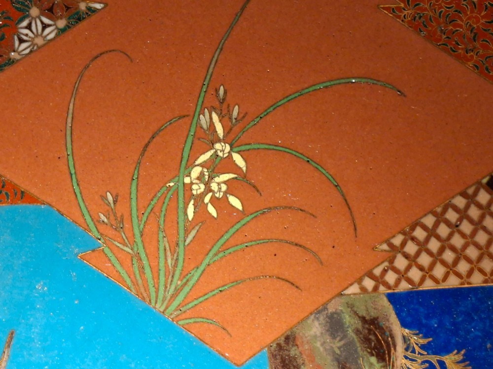 A circular Japanese cloisonne enamel plate featuring geometric patterned borders around asymmetrical panels depicting flora, a bird, and a nocturnal coastal scene. View IV