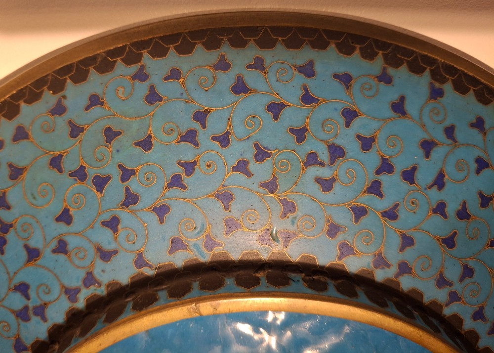 A circular Japanese cloisonne enamel plate featuring geometric patterned borders around asymmetrical panels depicting flora, a bird, and a nocturnal coastal scene. View XIV