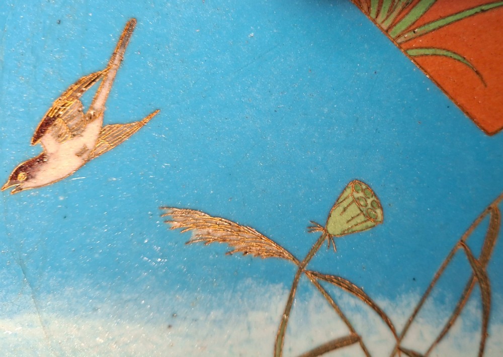 A circular Japanese cloisonne enamel plate featuring geometric patterned borders around asymmetrical panels depicting flora, a bird, and a nocturnal coastal scene. View XV