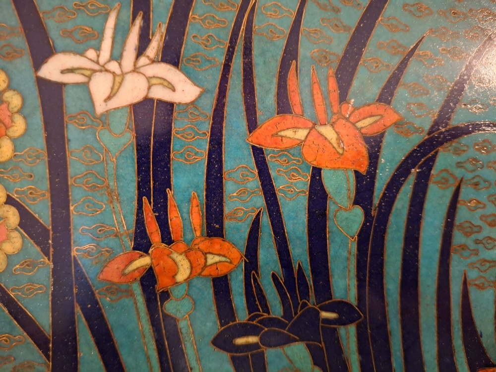 An oval Japanese cloisonne enamel tray featuring a turquoise background decorated with blue and orange iris flowers alongside geometric lattice patterns. View V