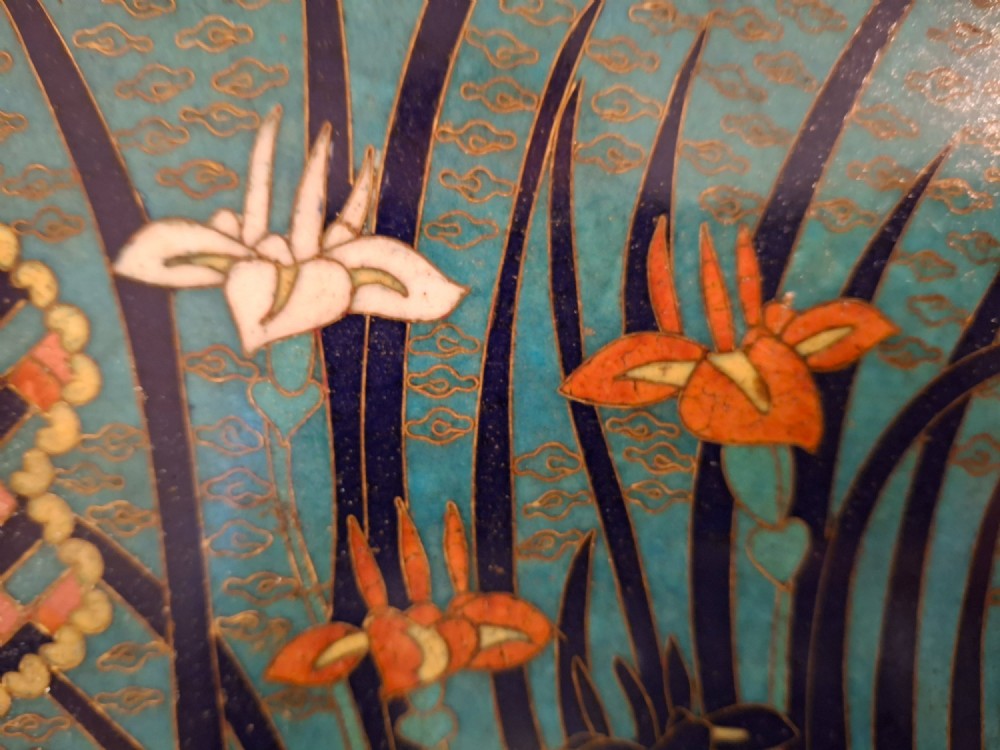 An oval Japanese cloisonne enamel tray featuring a turquoise background decorated with blue and orange iris flowers alongside geometric lattice patterns. View VII
