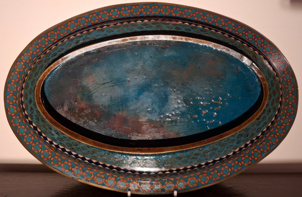 An oval Japanese cloisonne enamel tray featuring a turquoise background decorated with blue and orange iris flowers alongside geometric lattice patterns. View VIII