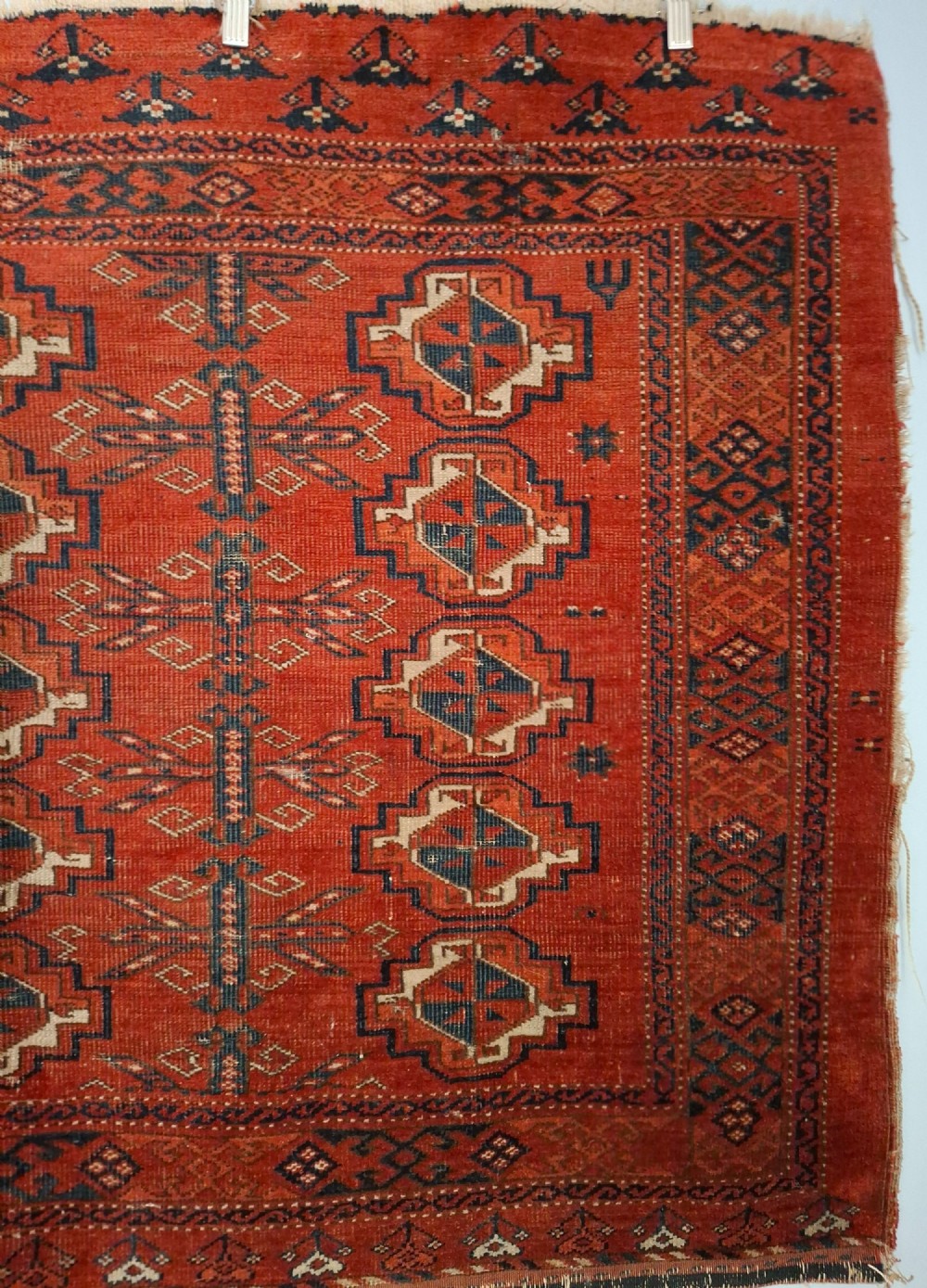 A rectangular antique handwoven wool Ersari Turkoman chuval face featuring fifteen stepped octagonal gul motifs arranged on a deep rust-red field within geometric borders. View III