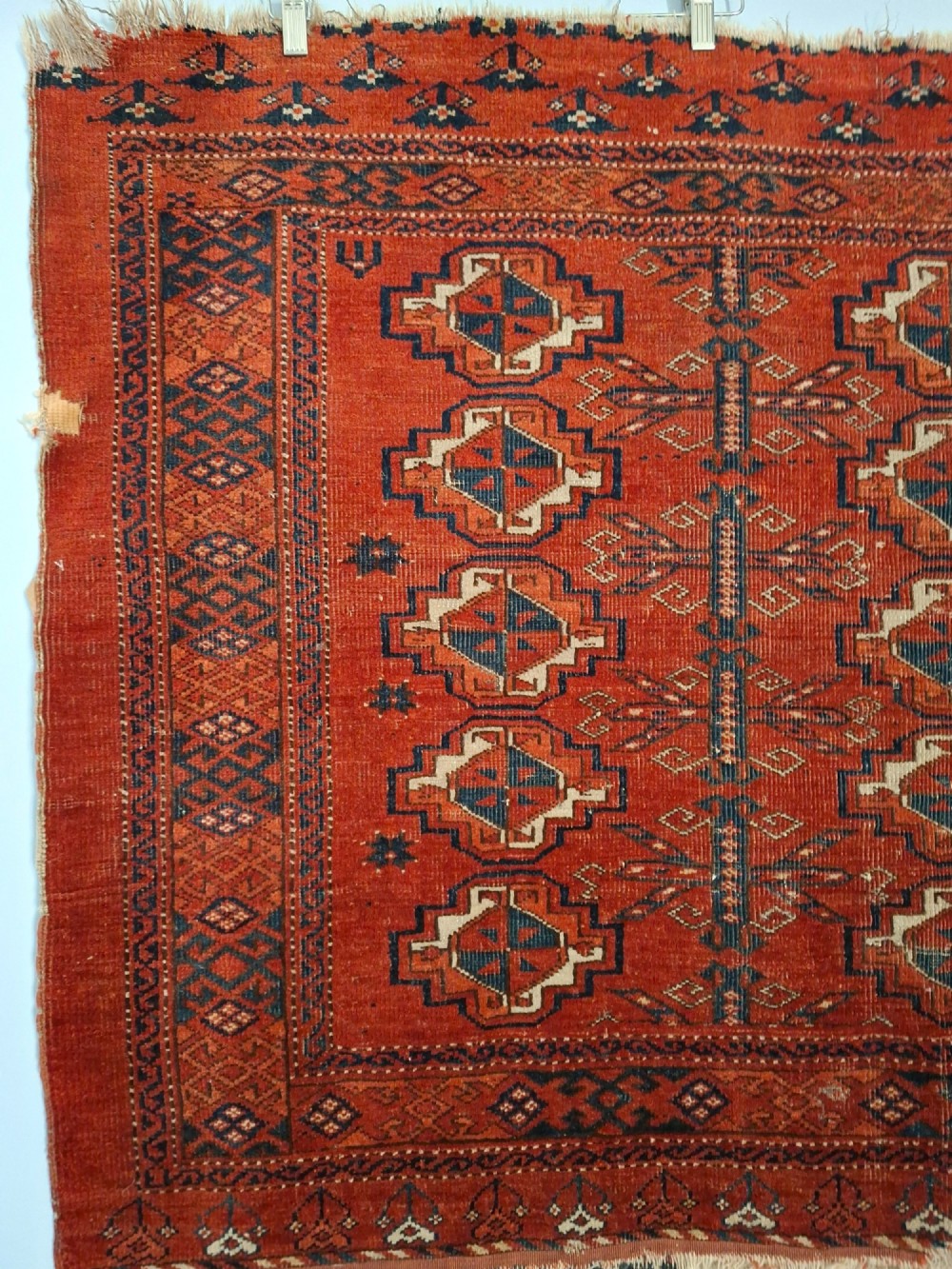 A rectangular antique handwoven wool Ersari Turkoman chuval face featuring fifteen stepped octagonal gul motifs arranged on a deep rust-red field within geometric borders. View IV