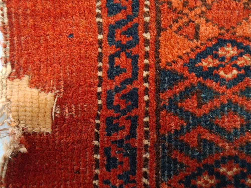 A rectangular antique handwoven wool Ersari Turkoman chuval face featuring fifteen stepped octagonal gul motifs arranged on a deep rust-red field within geometric borders. View VIII