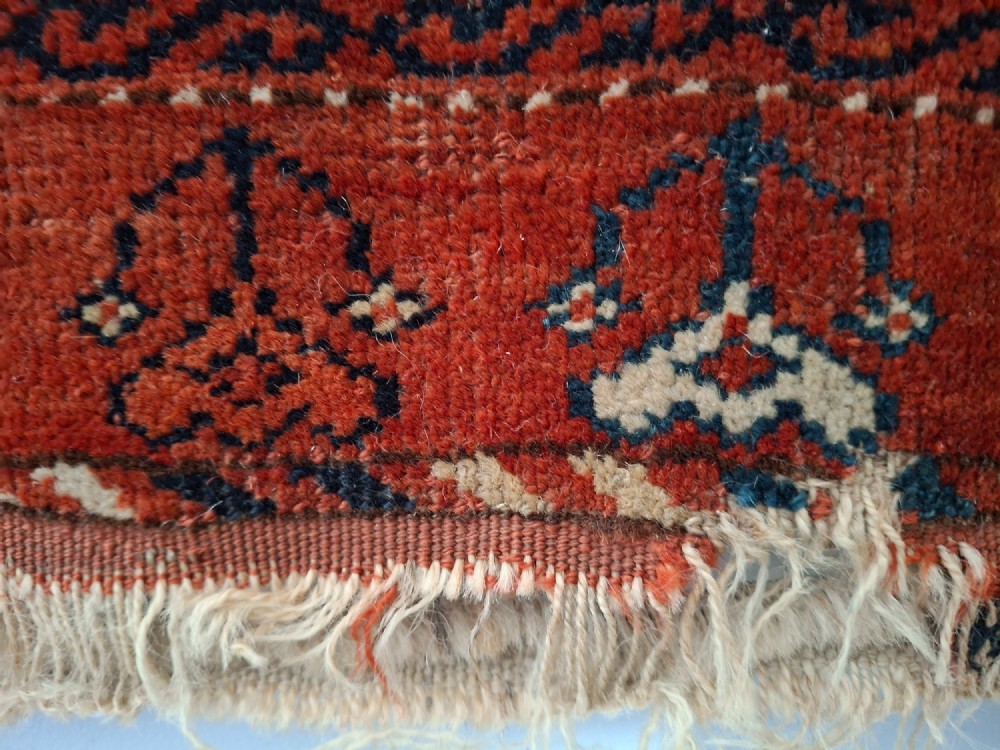 A rectangular antique handwoven wool Ersari Turkoman chuval face featuring fifteen stepped octagonal gul motifs arranged on a deep rust-red field within geometric borders. View IX