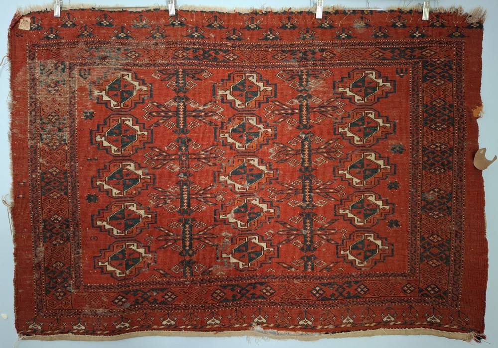 A rectangular antique handwoven wool Ersari Turkoman chuval face featuring fifteen stepped octagonal gul motifs arranged on a deep rust-red field within geometric borders. View XI